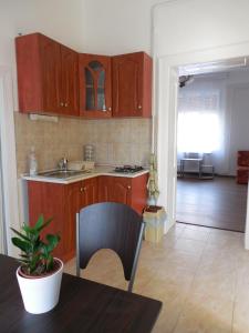 a kitchen with wooden cabinets and a table in a room at ENZO Apartman Gyula in Gyula