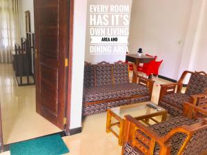 a room with chairs and a table and a sign at Mindana Residence in Anuradhapura