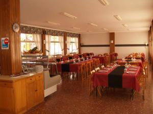 a dining room with tables and chairs with red tablecloths at Camping Playa América Nigrán in Playa América