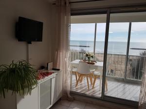 a kitchen with a table and a view of the ocean at Appartement T2 valras plage in Valras-Plage