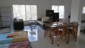 a living room with a table and chairs at teak trail in Pune