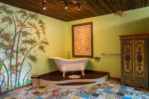 a bathroom with a tub in the corner of a room at Bali Bohemia Huts in Ubud