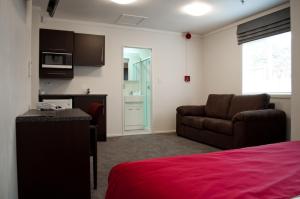 a living room with a bed and a couch at At Eden Park Motel in Auckland