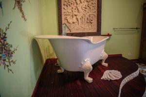 a white bath tub sitting in a bathroom at Bali Bohemia Huts in Ubud