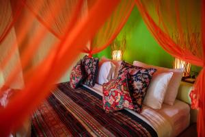 a bedroom with a bed with red curtains at Bali Bohemia Huts in Ubud