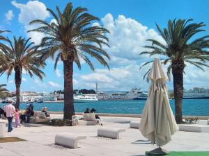 una playa con palmeras y una sombrilla cerrada en Apartment Marmonaut en Split