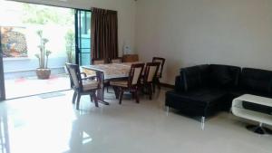 uma sala de estar com uma mesa e cadeiras e um sofá em สุชาวลัย แอท ซี ชะอำ em Cha Am