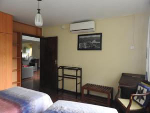 a room with a bedroom with a bed and a chair at Hanthana Breeze Home Stay in Kandy