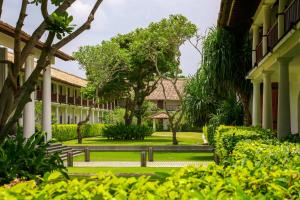 a courtyard of a building with trees and bushes at The Fortress Resort & Spa in Koggala