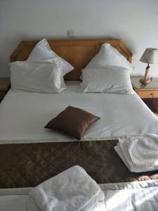a large bed with white sheets and pillows at Hotel El Biar in Alger