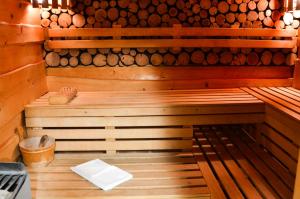 a sauna with a bench in front of a pile of logs at Hotel****Liptovský dvor in Liptovský Ján