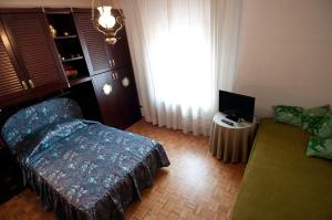 a bedroom with a bed and a couch and a window at La Casa Sul Fiume in San Daniele del Friuli