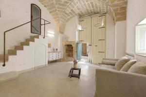 a living room with a couch and a staircase at Relais Palazzo Zaccaria in Matino