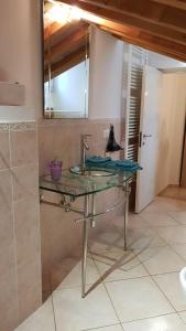 y baño con lavabo de cristal y espejo. en La casa di Oliva, en Macerata