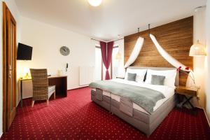 ブルノにあるHotel Sharinghamの大きなベッドとデスクが備わるホテルルームです。
