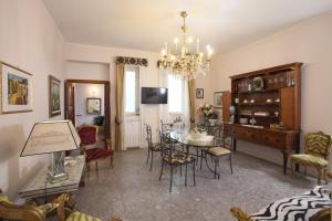 una sala da pranzo con tavolo, sedie e lampadario pendente di Porta Di Mezzo Luxury Suites & Rooms a Taormina