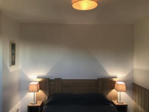 ein Schlafzimmer mit einem Bett und zwei Lampen an Tischen in der Unterkunft T2 Duplex Valentin Plage in Batz-sur-Mer