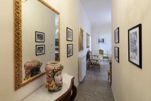 タオルミーナにあるPorta Di Mezzo Luxury Suites & Roomsの鏡と花瓶が置かれた廊下