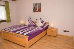 1 cama con almohadas moradas y blancas en una habitación en Ferienhaus Alina, en Bernkastel-Kues