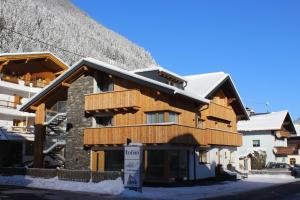 a ski lodge with a snow covered mountain in the background at Edelweiss Apartments 200m zum Lift in See