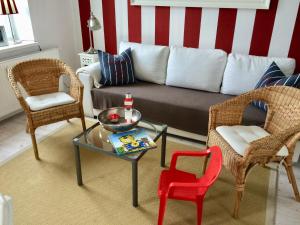 a living room with a couch and two chairs and a table at MÖWE in Ribnitz-Damgarten