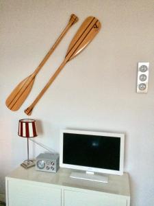 two baseball bats and a tv on a wall at MÖWE in Ribnitz-Damgarten