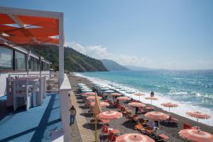 - une plage avec des parasols et des chaises et l'océan dans l'établissement GH Avalon Sikani, à Gioiosa Marea