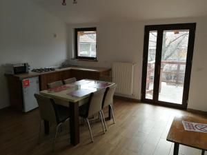 a kitchen with a table and chairs in a room at Casa Juliana in Rîu Bărbat