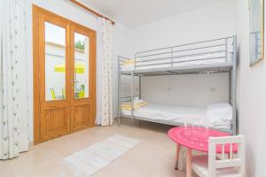 a small room with a bunk bed and a table at Can Miquel (Can Picafort) in Can Picafort