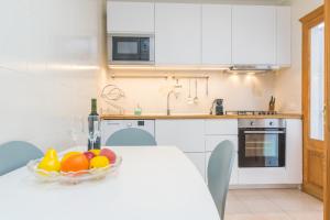 a kitchen with a table with a bowl of fruit on it at Can Miquel (Can Picafort) in Can Picafort +24 photos