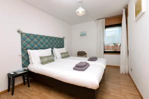 um quarto com uma grande cama branca e uma cabeceira verde em LV Premier Marques MQ2 no Porto