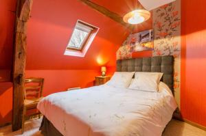 Laubresselにあるbaticelherのオレンジ色の壁のベッドルーム1室(大型ベッド1台付)
