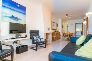 a living room with a blue couch and a tv at Can Miquel (Can Picafort) in Can Picafort