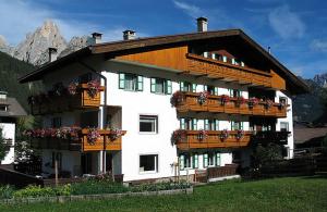 a large building with balconies and flowers on it at Cesa Bernard in Pozza di Fassa