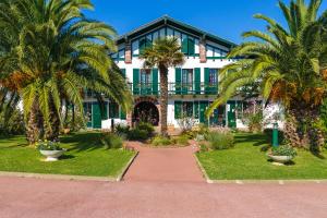 a building with palm trees in front of it at Azureva Hendaye in Hendaye