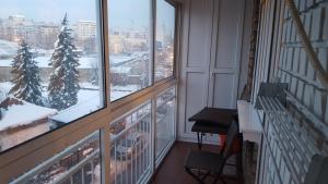 a balcony with a view of a snow covered city at Apartman Jogi in Vračar (historical)