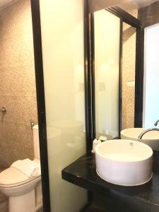 La salle de bains est pourvue d'un lavabo et de toilettes. dans l'établissement The Green Plaza Hotel, à Bangrak Beach