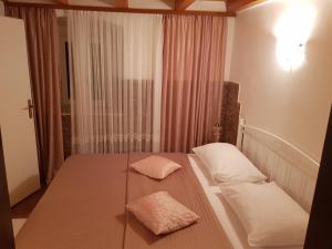 a bedroom with a bed with two pillows on it at Apartments Minerva in Dubrovnik