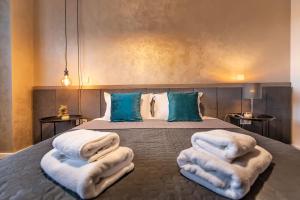 a bedroom with a bed with white blankets and pillows at Warm Amber Suites Brașov in Braşov