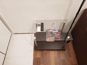 a glass table with a cell phone and books on it at Apartments Minerva in Dubrovnik