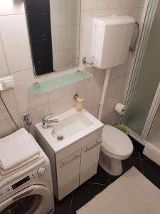 a bathroom with a sink and a washing machine at Apartments Minerva in Dubrovnik