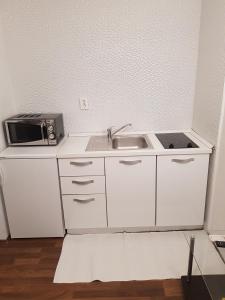 a small kitchen with a sink and a microwave at Apartments Minerva in Dubrovnik