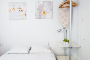 バルセロナにあるelPilar Sant Antoniのベッドルーム1室(ベッド1台付)が備わります。壁に2枚の写真が飾られています。
