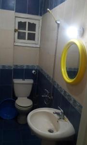 a bathroom with a toilet and a sink and a mirror at El Fardous Flowerللرجال فقط in Alexandria