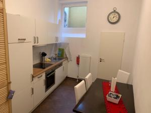 een keuken met een tafel en een klok aan de muur bij 5min City Zentral - Wohnen am Werdersee Neustadt in Bremen