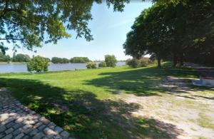 a grassy field with trees and a lake at 5min City Zentral - Wohnen am Werdersee Neustadt in Bremen