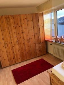 Habitación con armarios de madera y alfombra roja. en Julien Felix 1 en Kierspe
