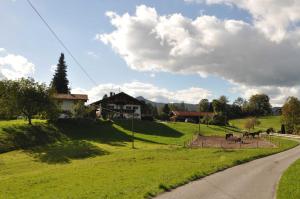 ein Haus auf einem Hügel neben einer Straße in der Unterkunft Greinhof in Fischbachau