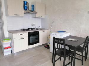 a kitchen with a stove and a table and chairs at Bed and Breakfast Mezzanotte in Balvano