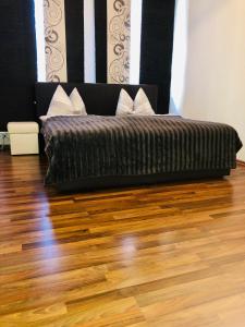 Cama en habitación con suelo de madera en Ferienparadies, en Fürth